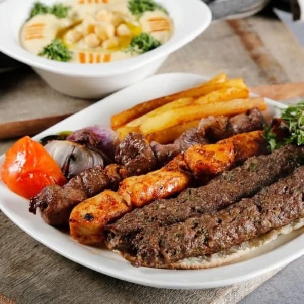 Cinar Restaurant's Mediterranean platter with various kebabs, fries, grilled vegetables, and hummus.